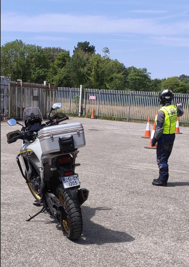 Mick Nolan directing a motorcycle training exercise around cones in a controlled training area.